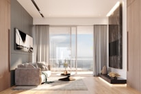 Modern living room with large window and ocean view.