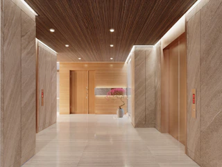 Modern hotel lobby with elevators and wood accents.