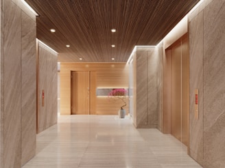 Modern hotel lobby with elevators and wood accents.