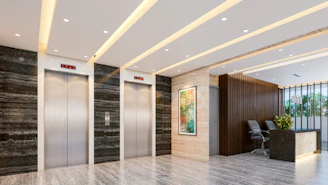 Modern lobby with elevators and reception desk.