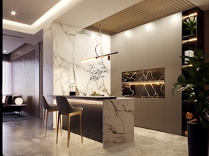 Modern kitchen island with marble accents and pendant light.