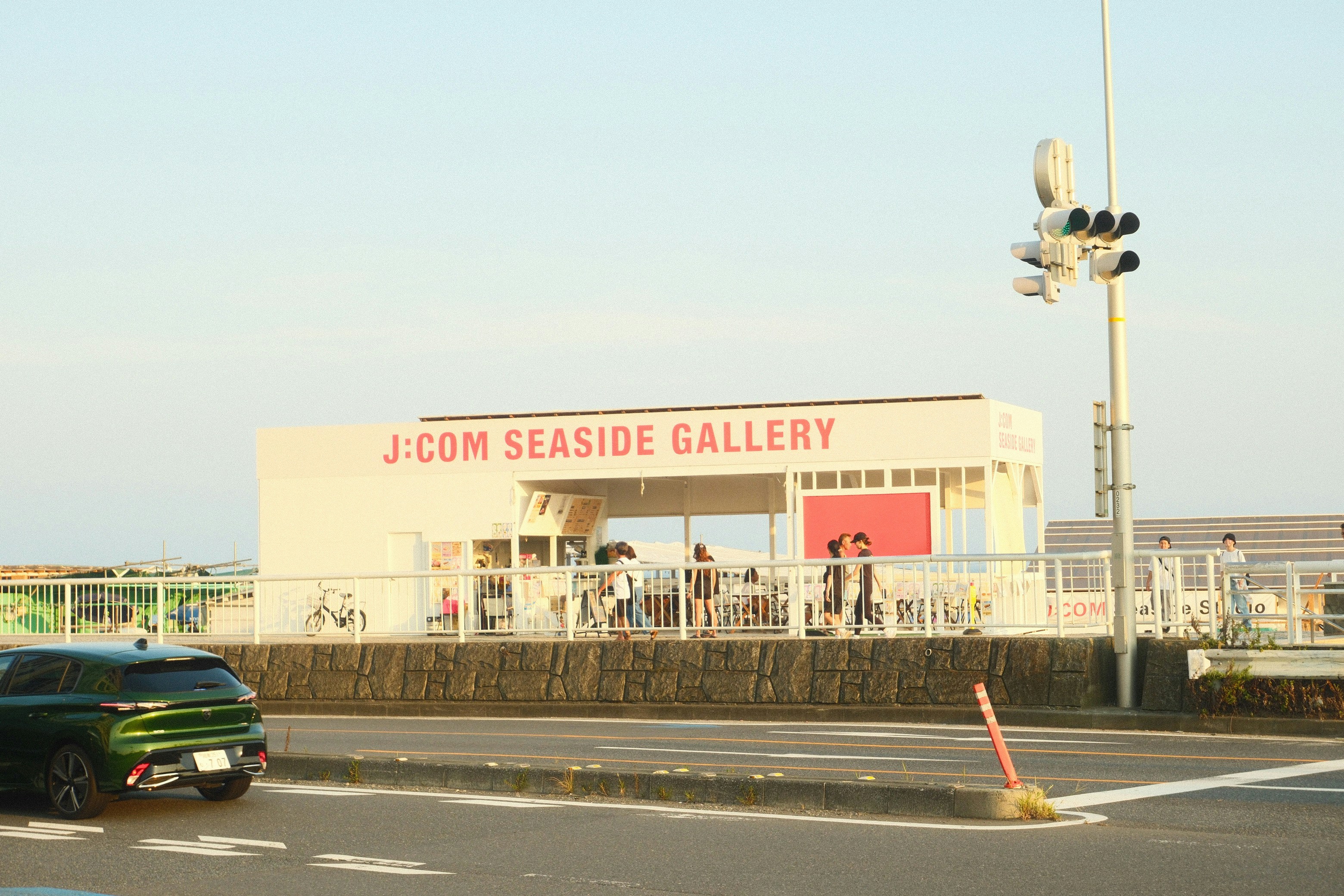 J-com seaside gallery building with people outside