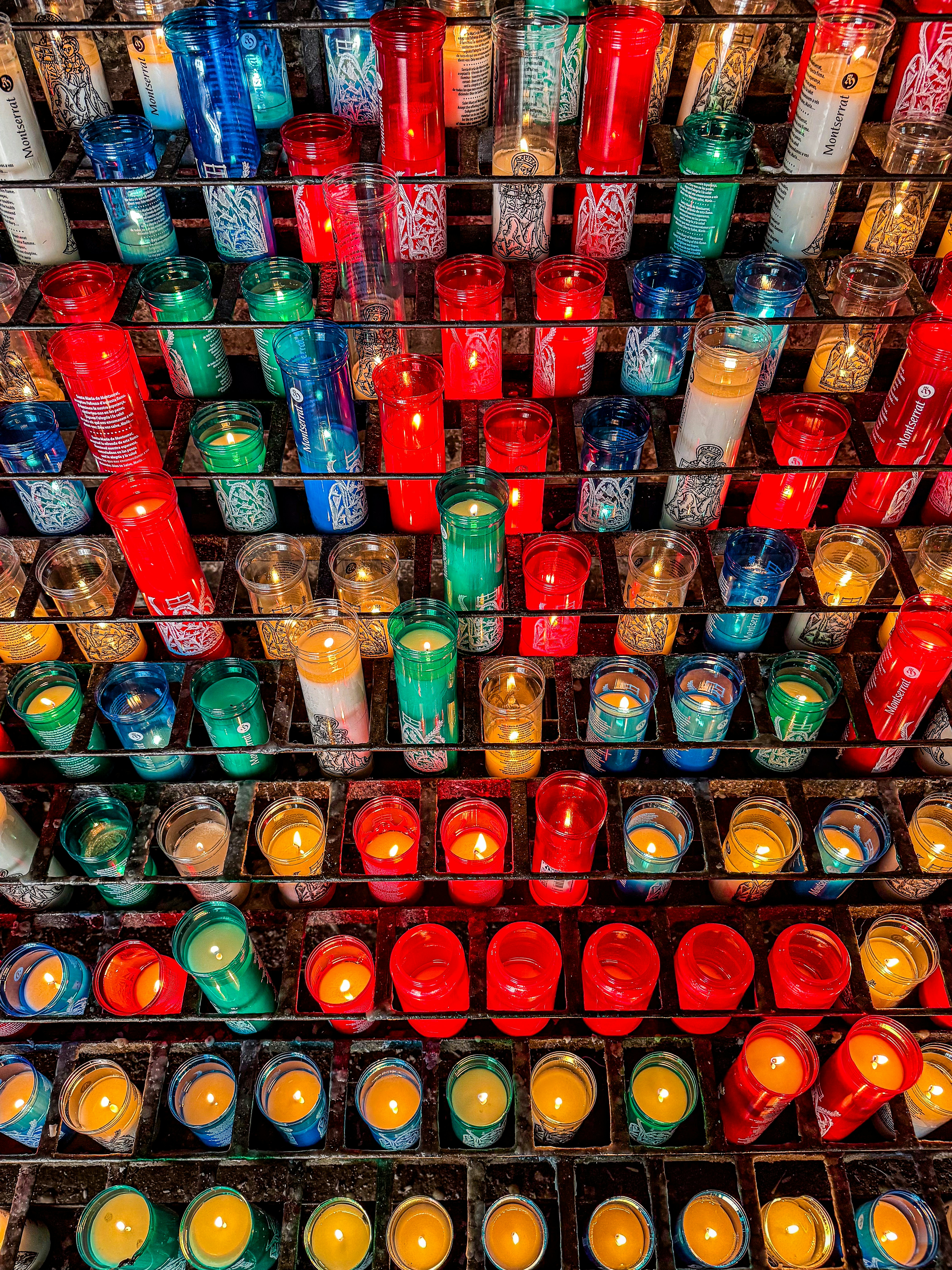 홀더에 줄지어 늘어선 다채로운 봉헌 양초