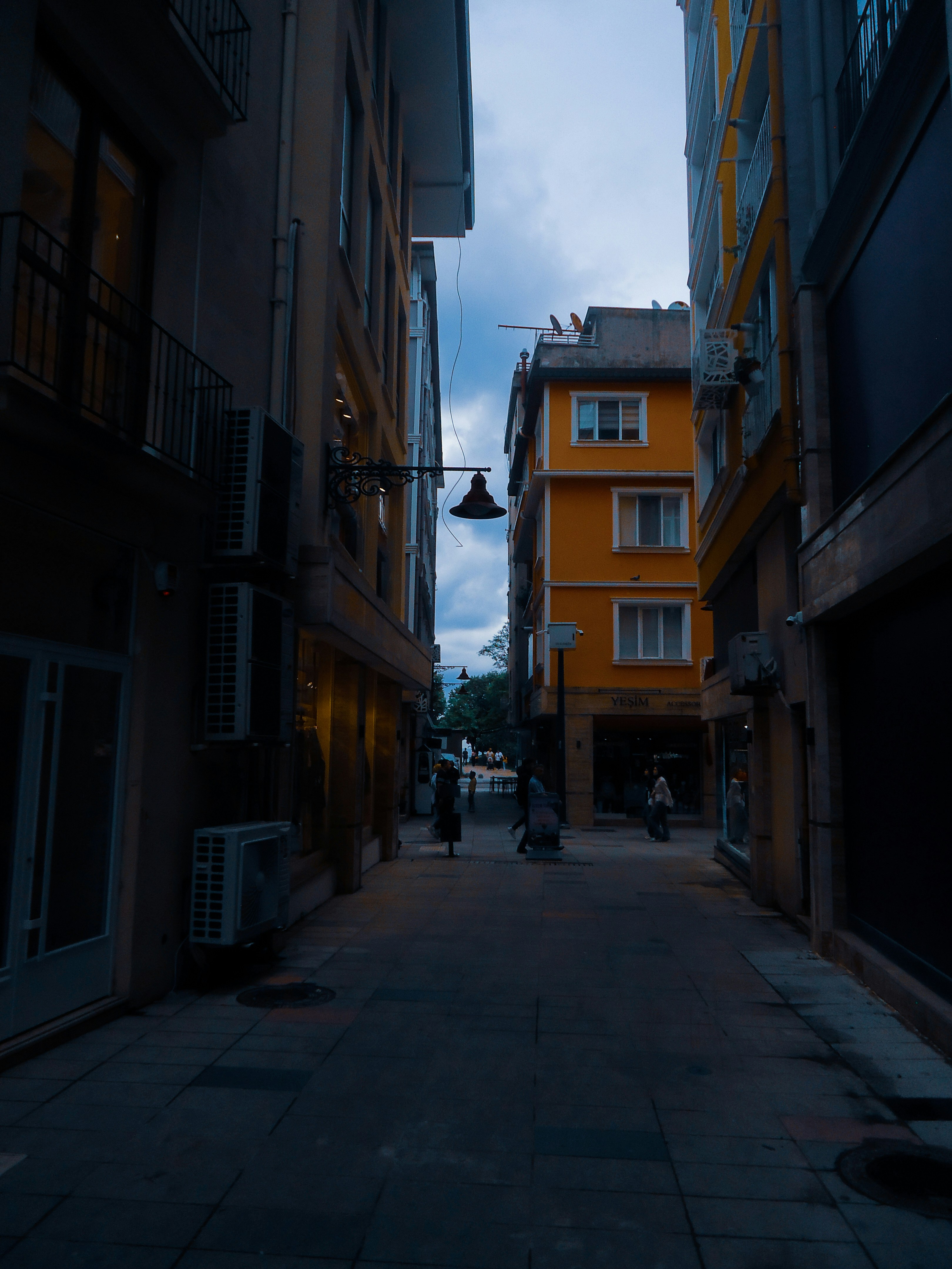 Narrow street between buildings with a bright yellow one.