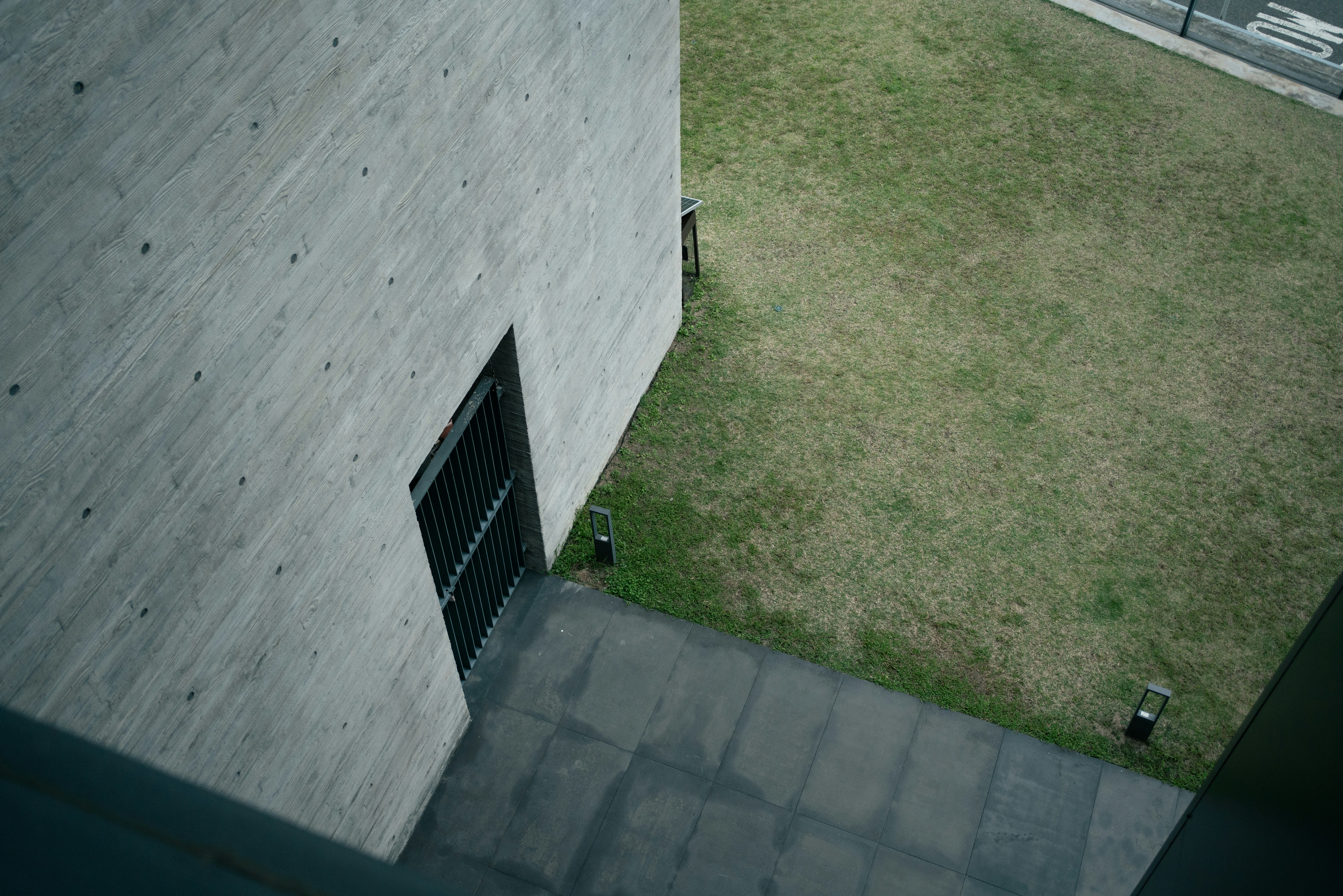 Concrete building exterior with grassy courtyard and pathway. 풍경 사진