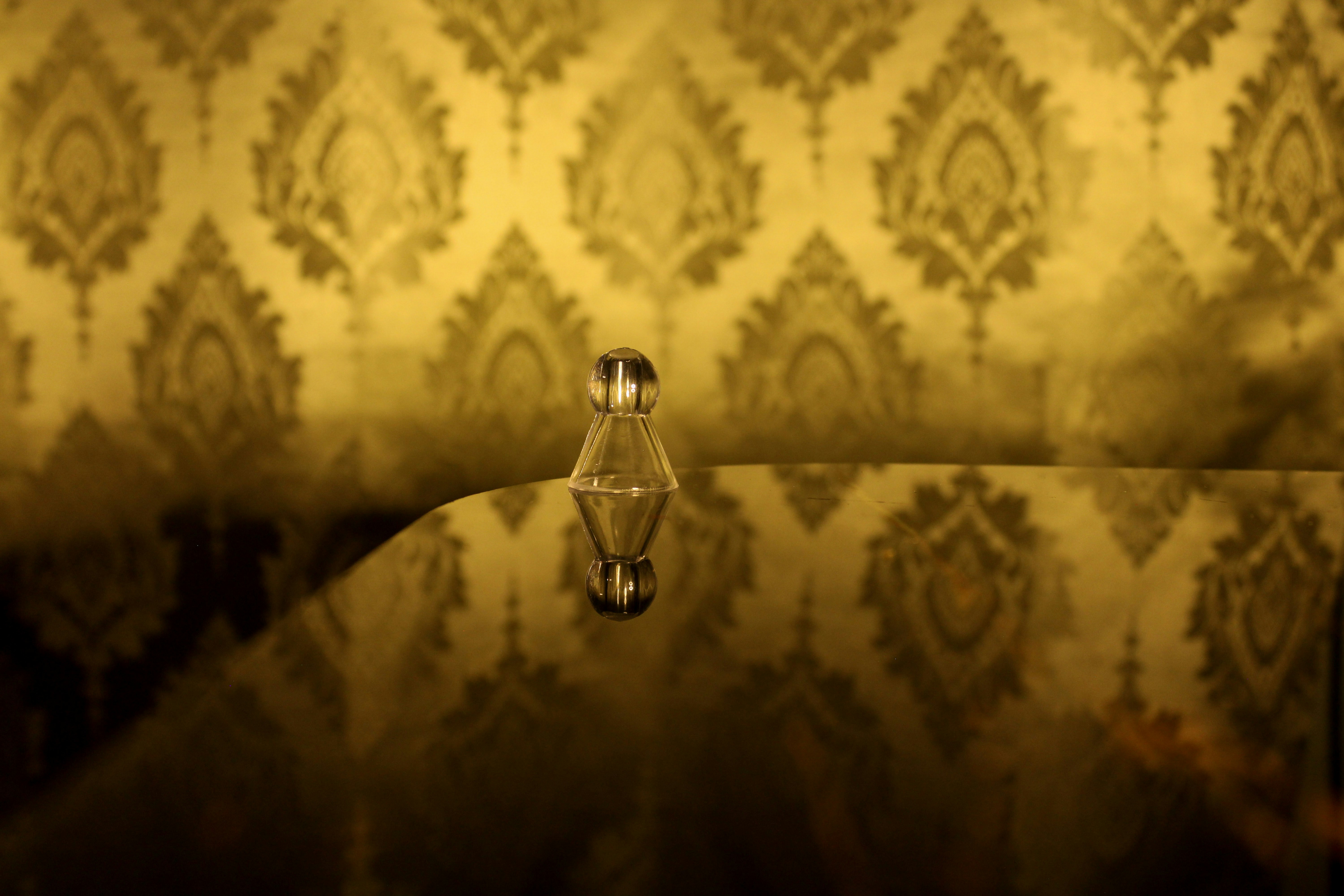 A glass chess piece on a reflective surface.