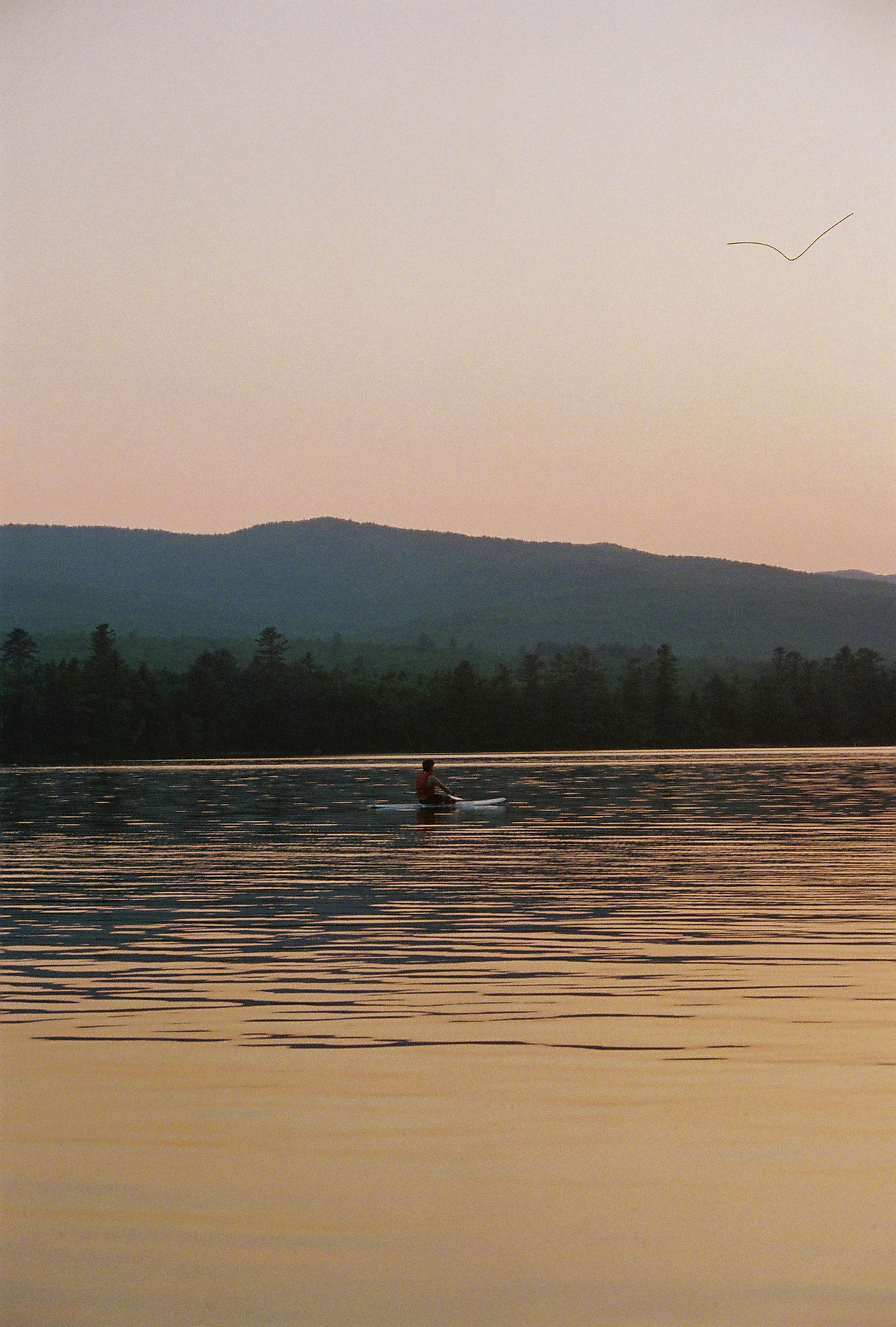 Person waterskiing on a lake at sunset