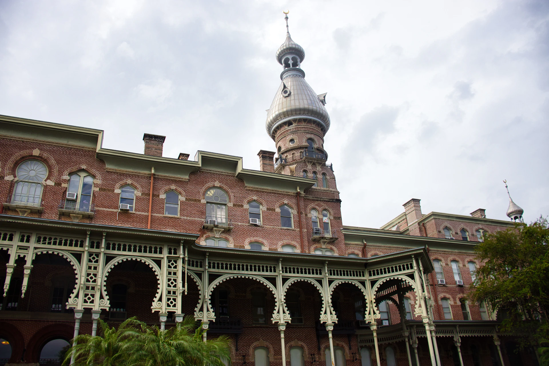 Historic brick building with ornate balconies and tower.