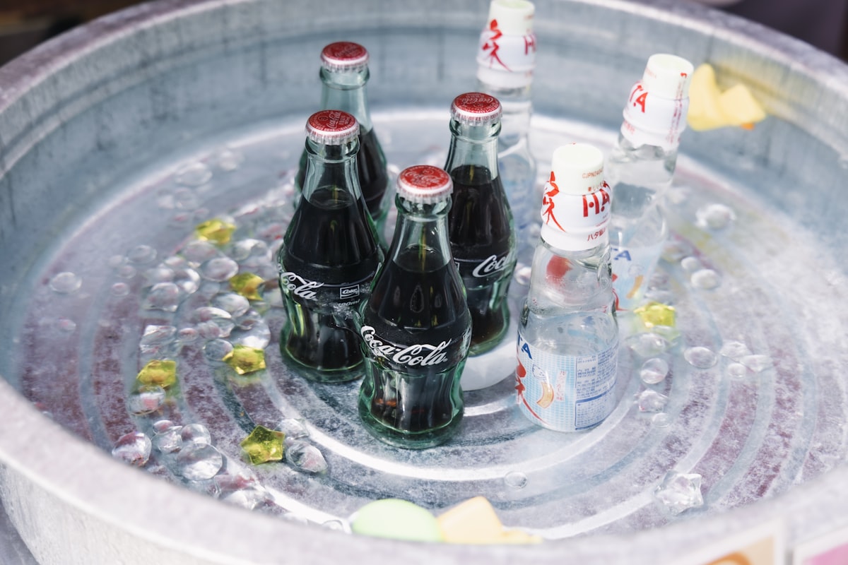 Glass bottles of soda chilling in ice, representing the beverage industry