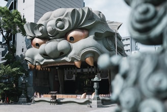 Stone lion head building facade with golden eyes.