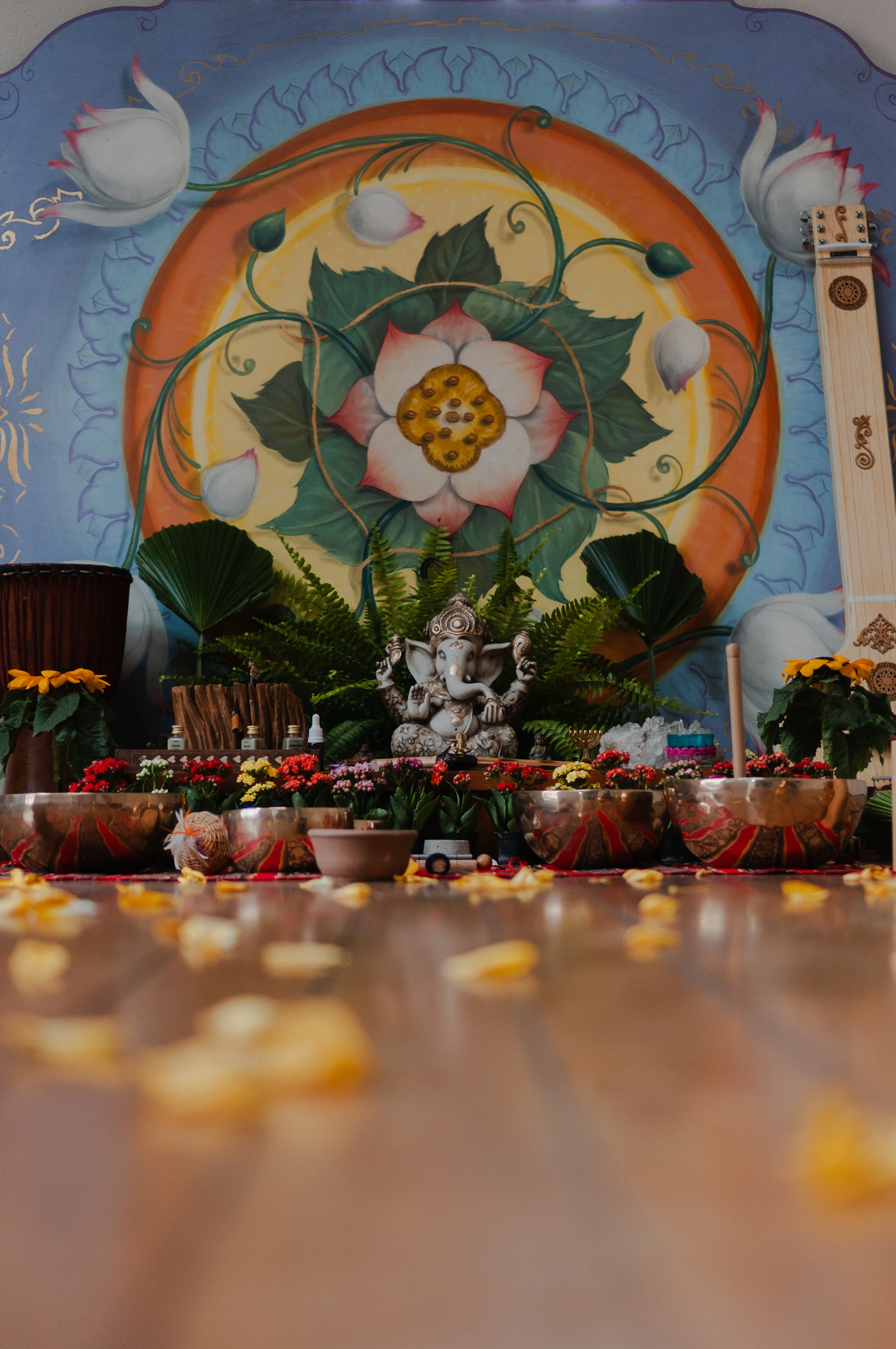 Ganesha statue with singing bowls and floral decor