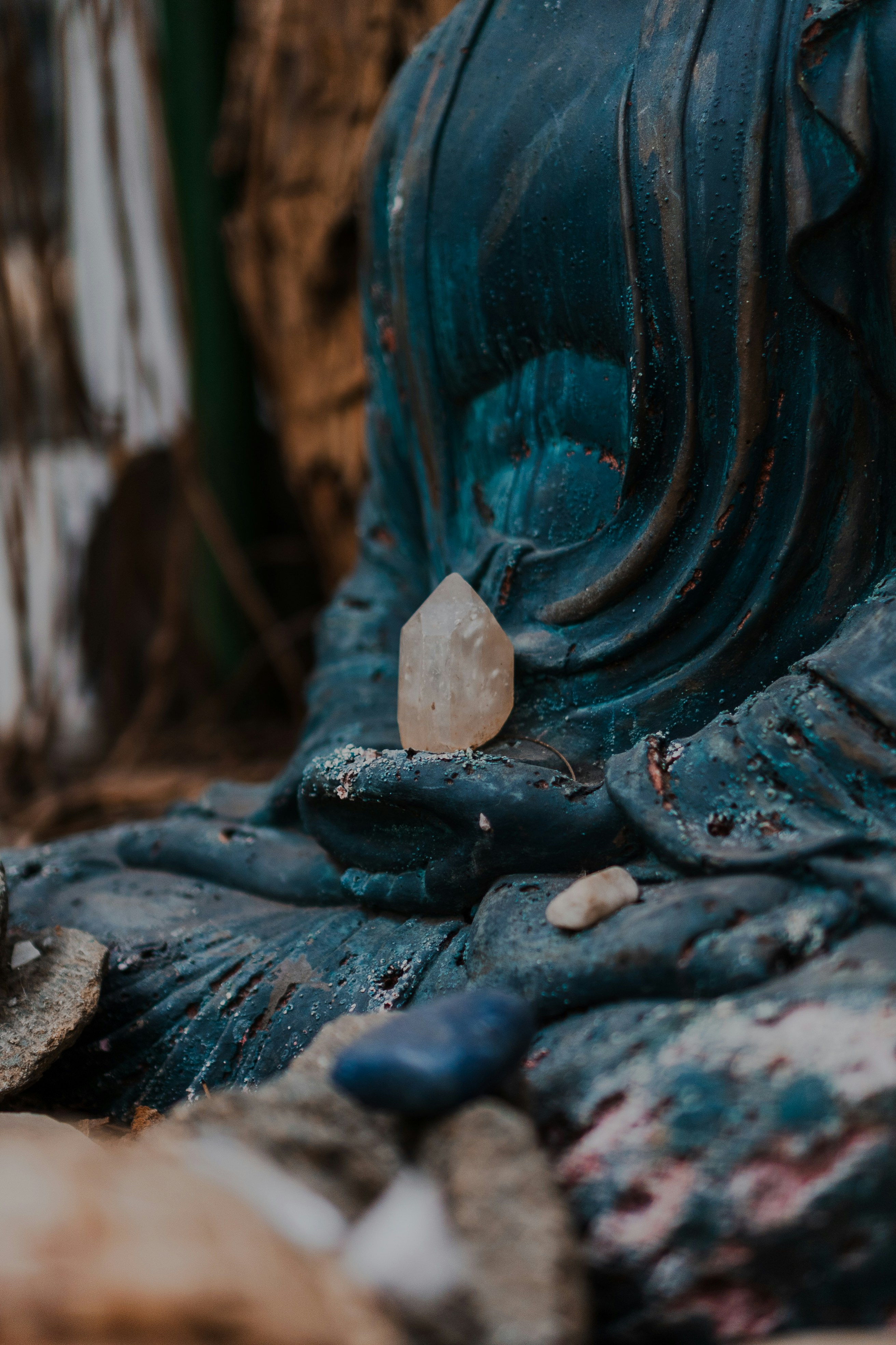 Close-up of a weathered buddha statue with crystals.