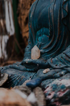Close-up of a weathered buddha statue with crystals.