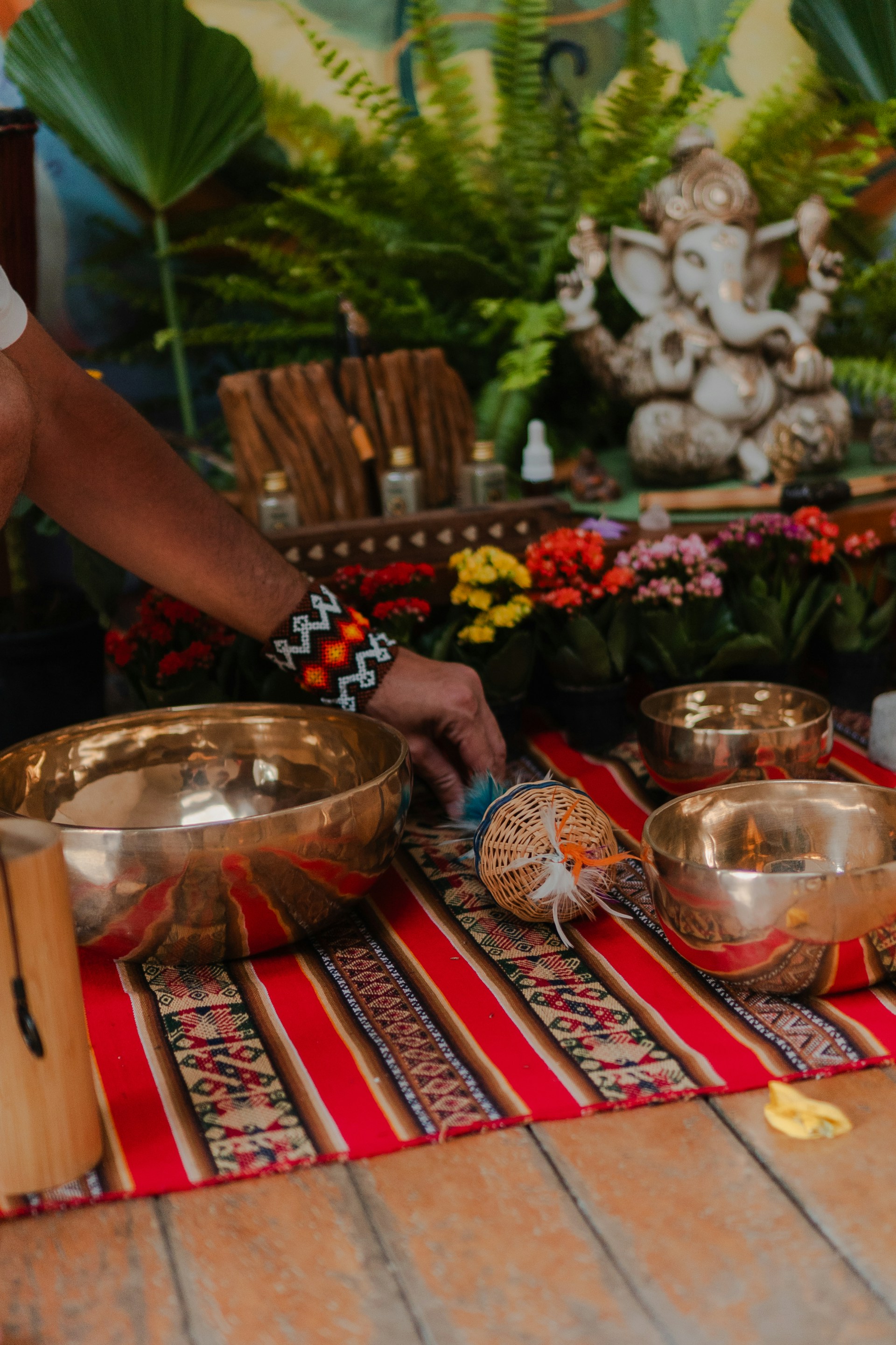Singing bowls and ganesha statue on a colorful mat