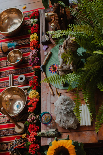 Tibetan singing bowls with flowers and crystals on table