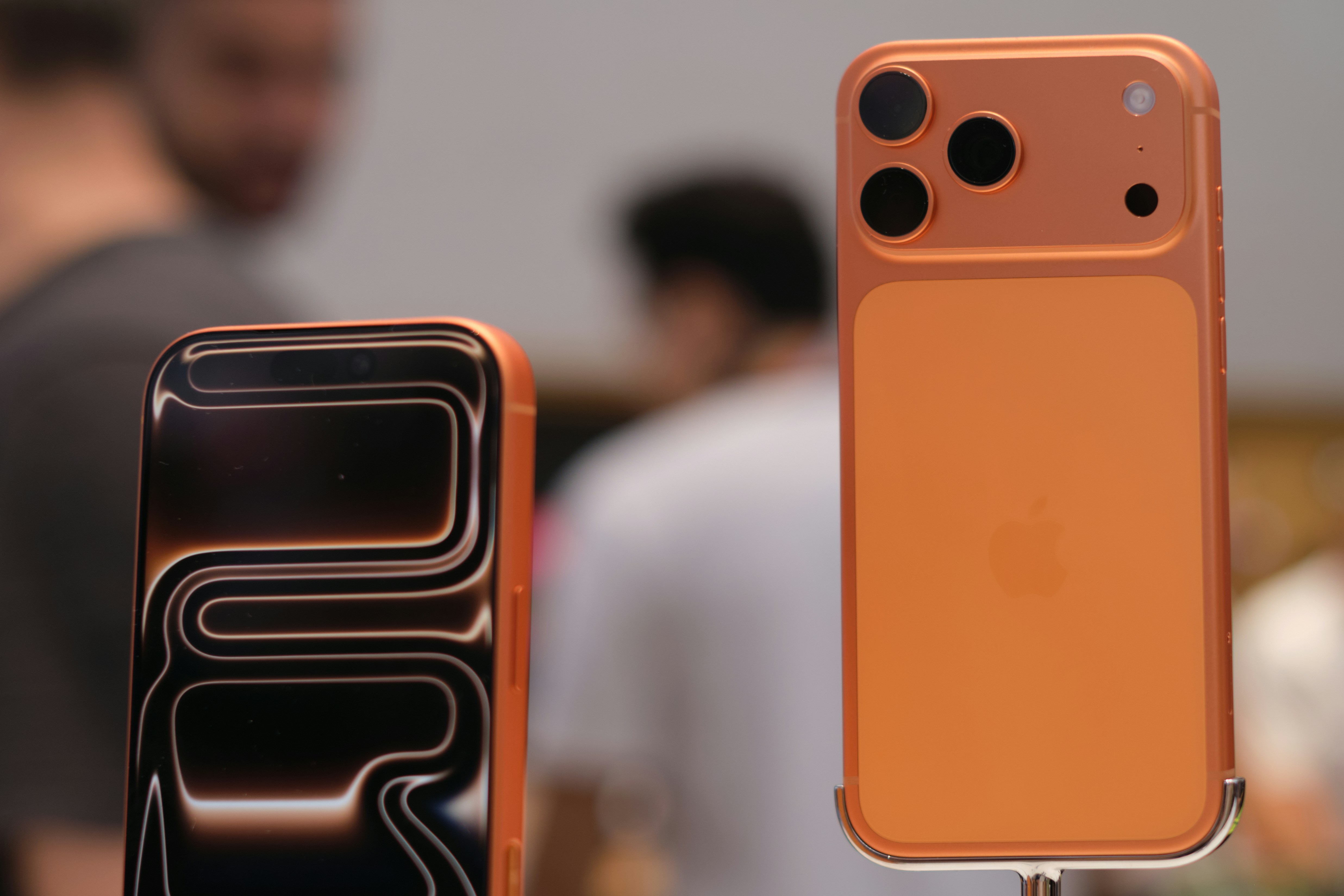 オレンジ色のスマートフォン2台が並べて展示されています。