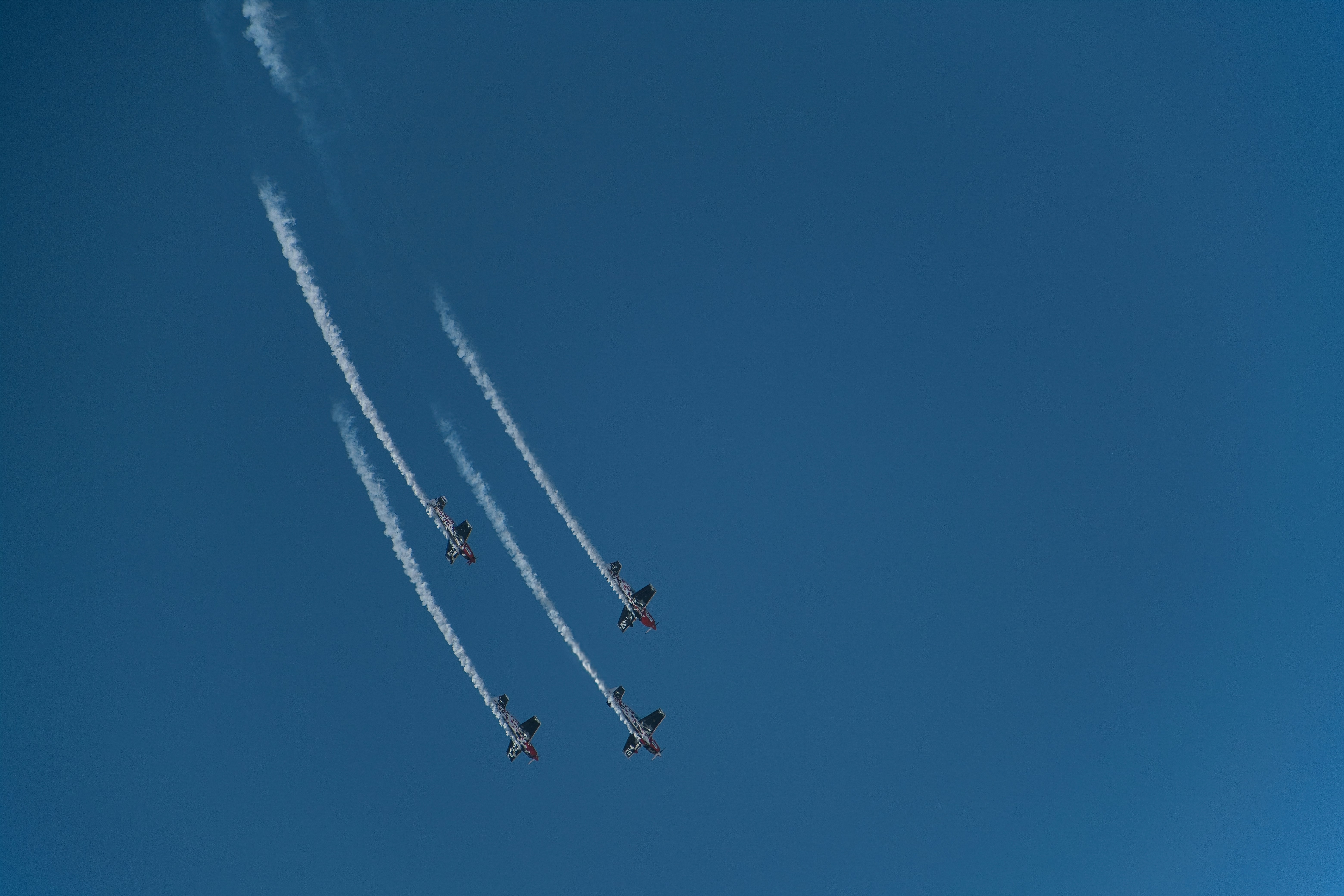 Cuatro aviones volando en formación dejando rastros de humo.