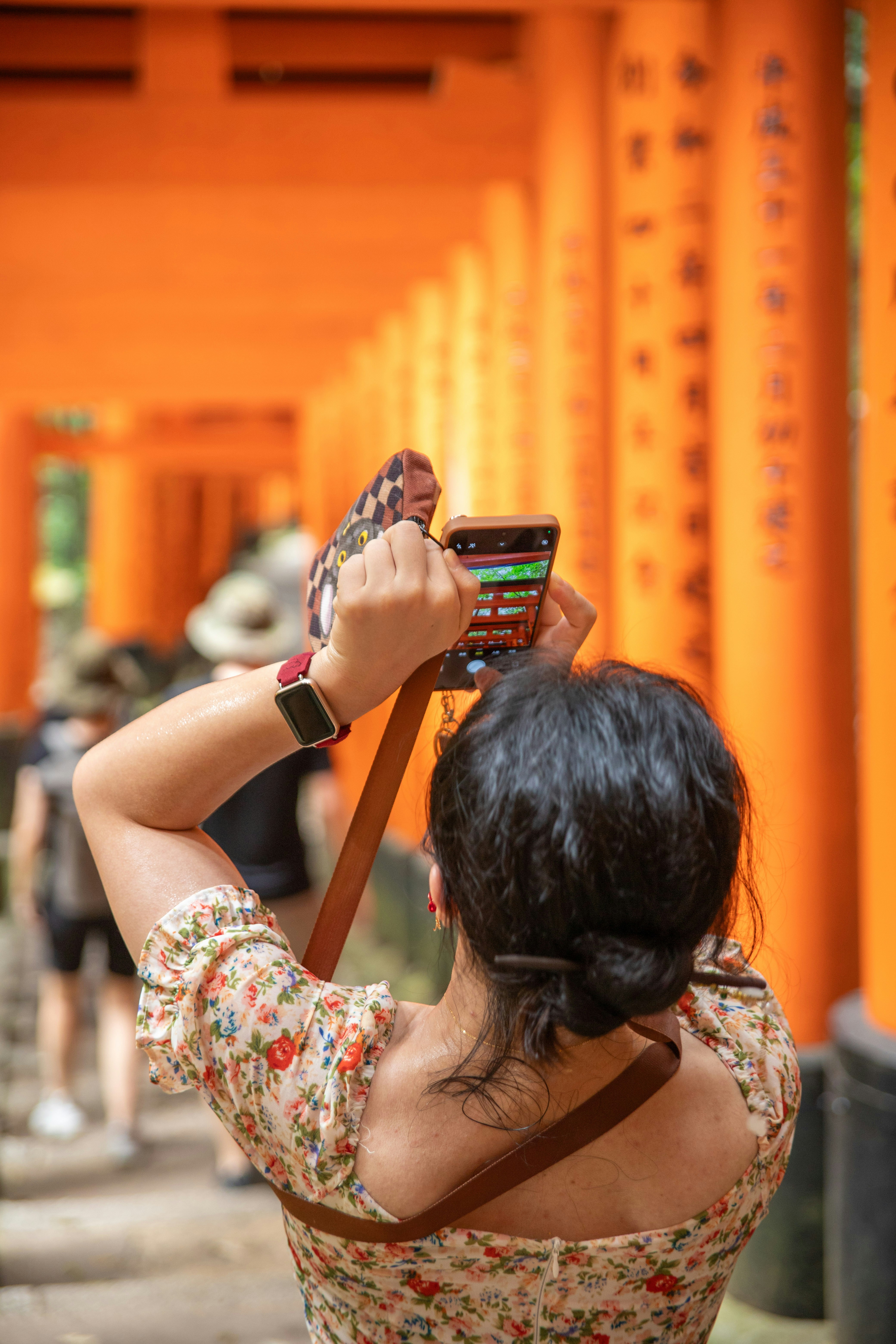 Woman taking a picture with her phone in a shrine