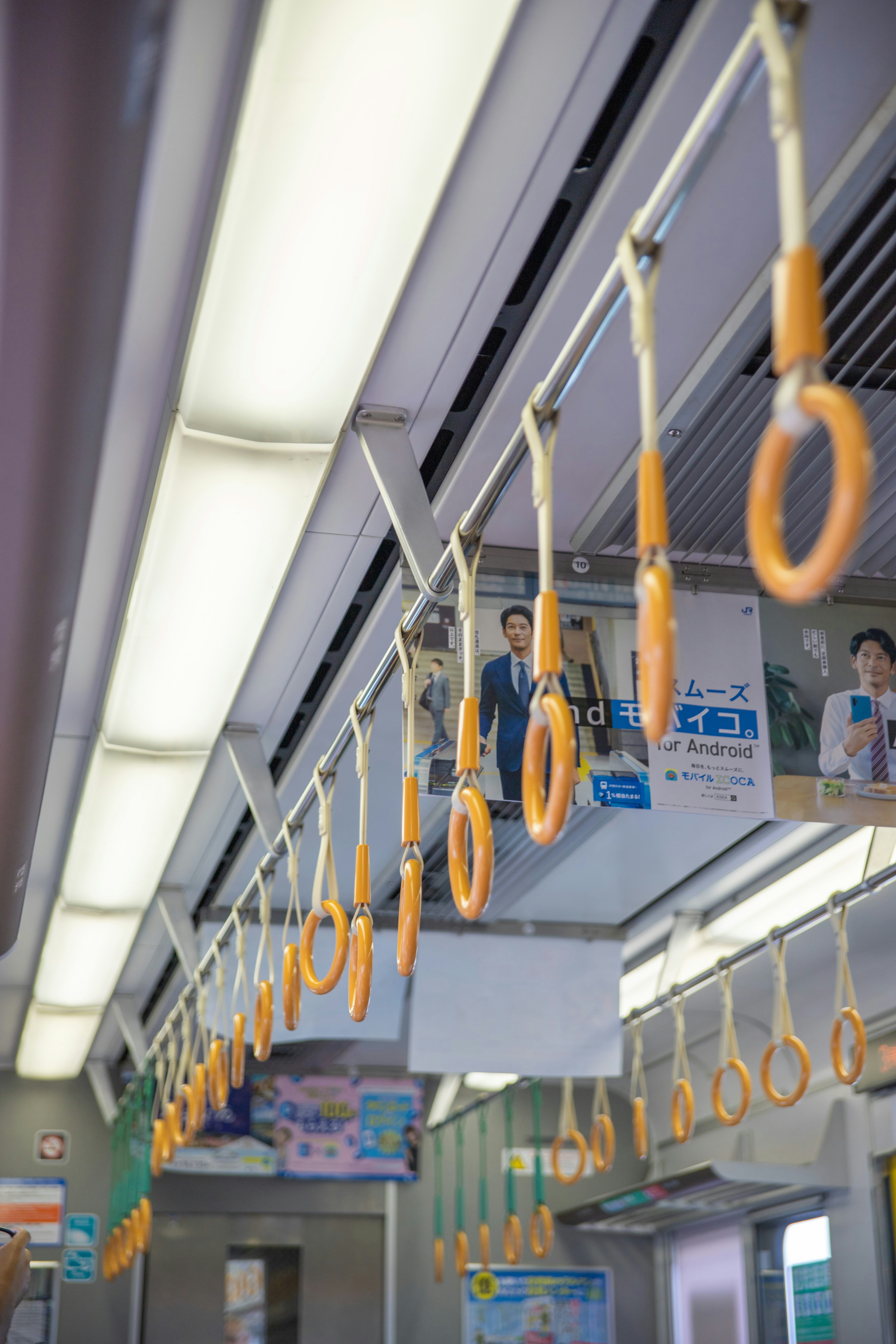 Orange hanging straps inside a train carriage