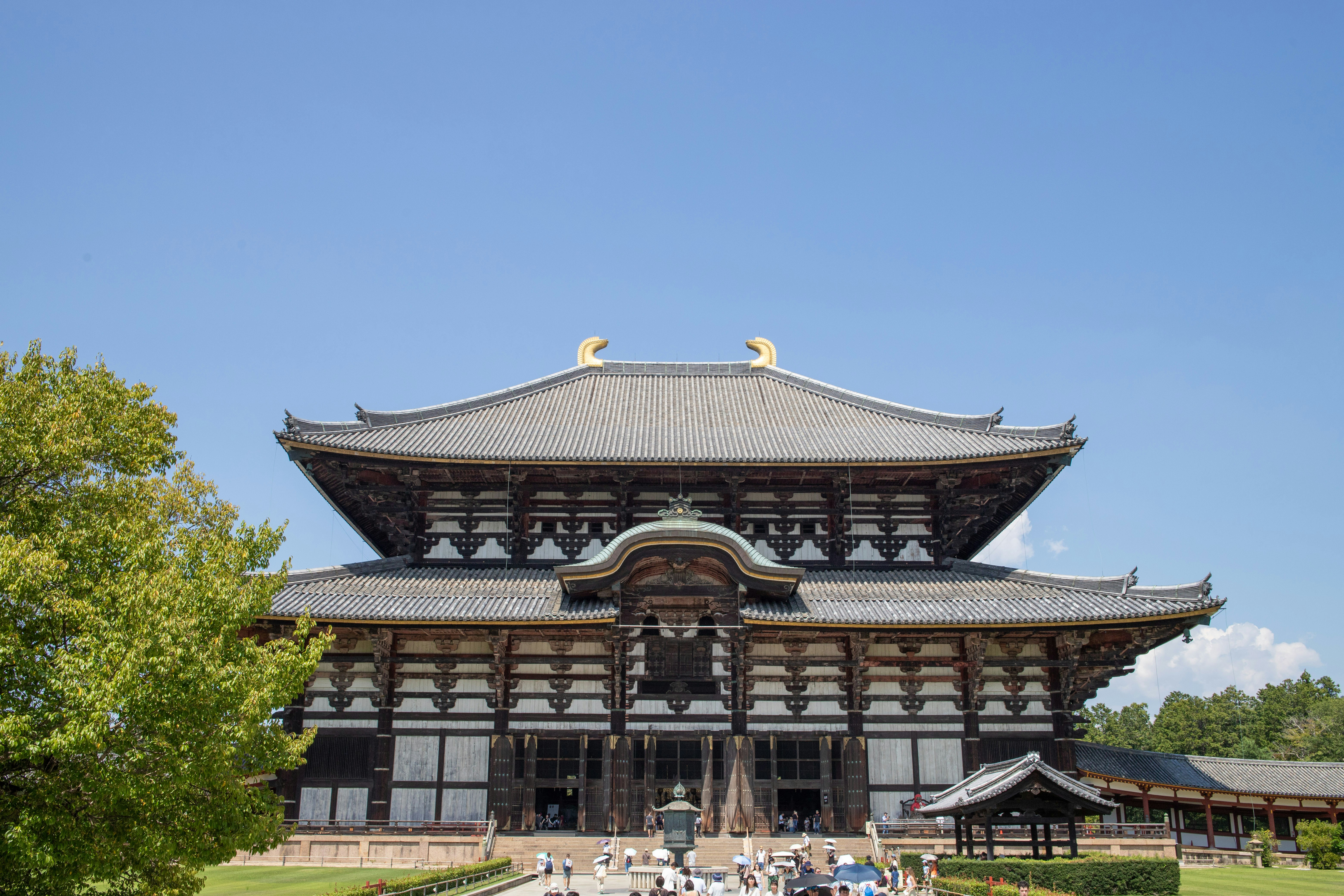 Large traditional japanese temple under a clear blue sky.