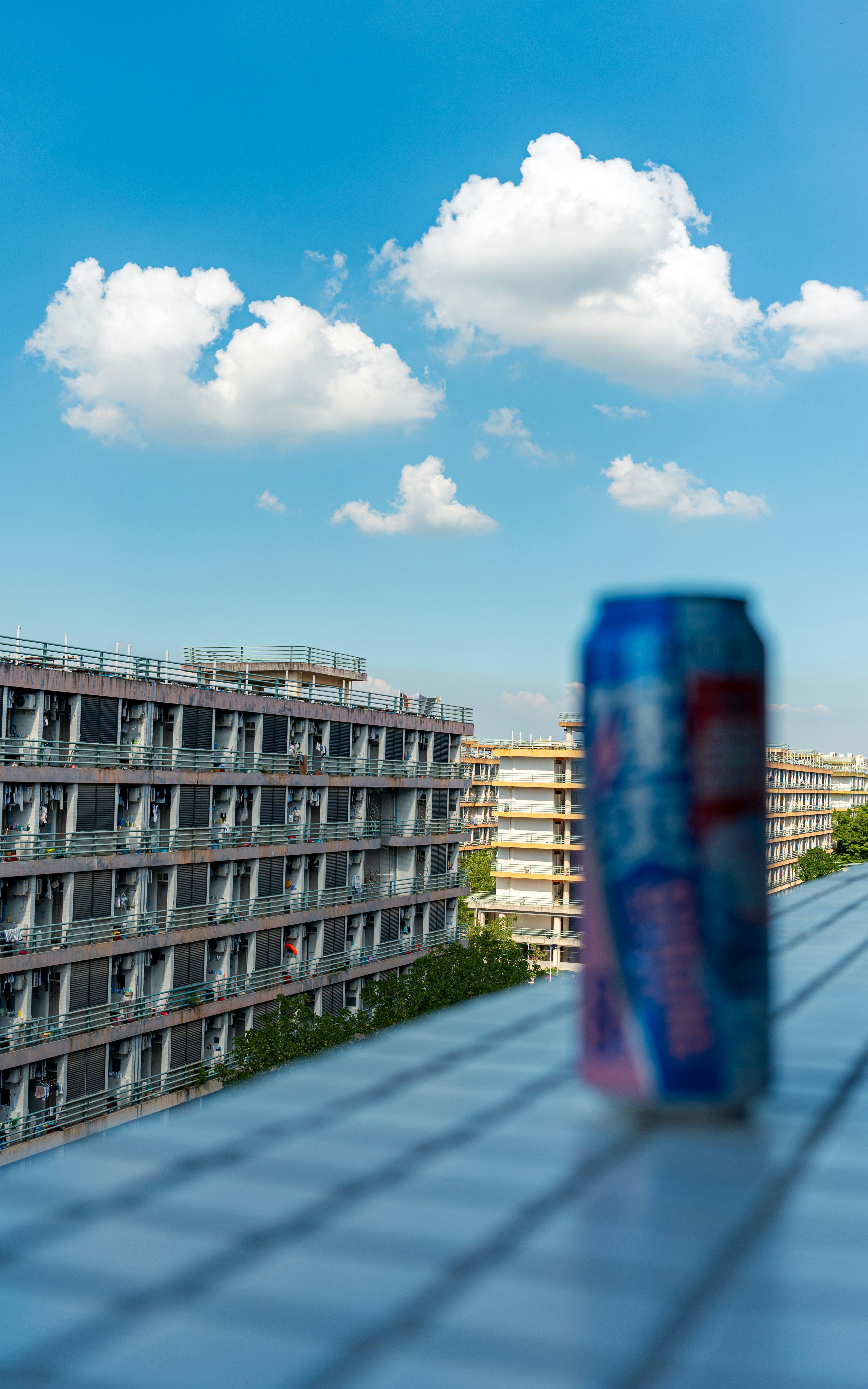 Blue soda can on balcony overlooking buildings