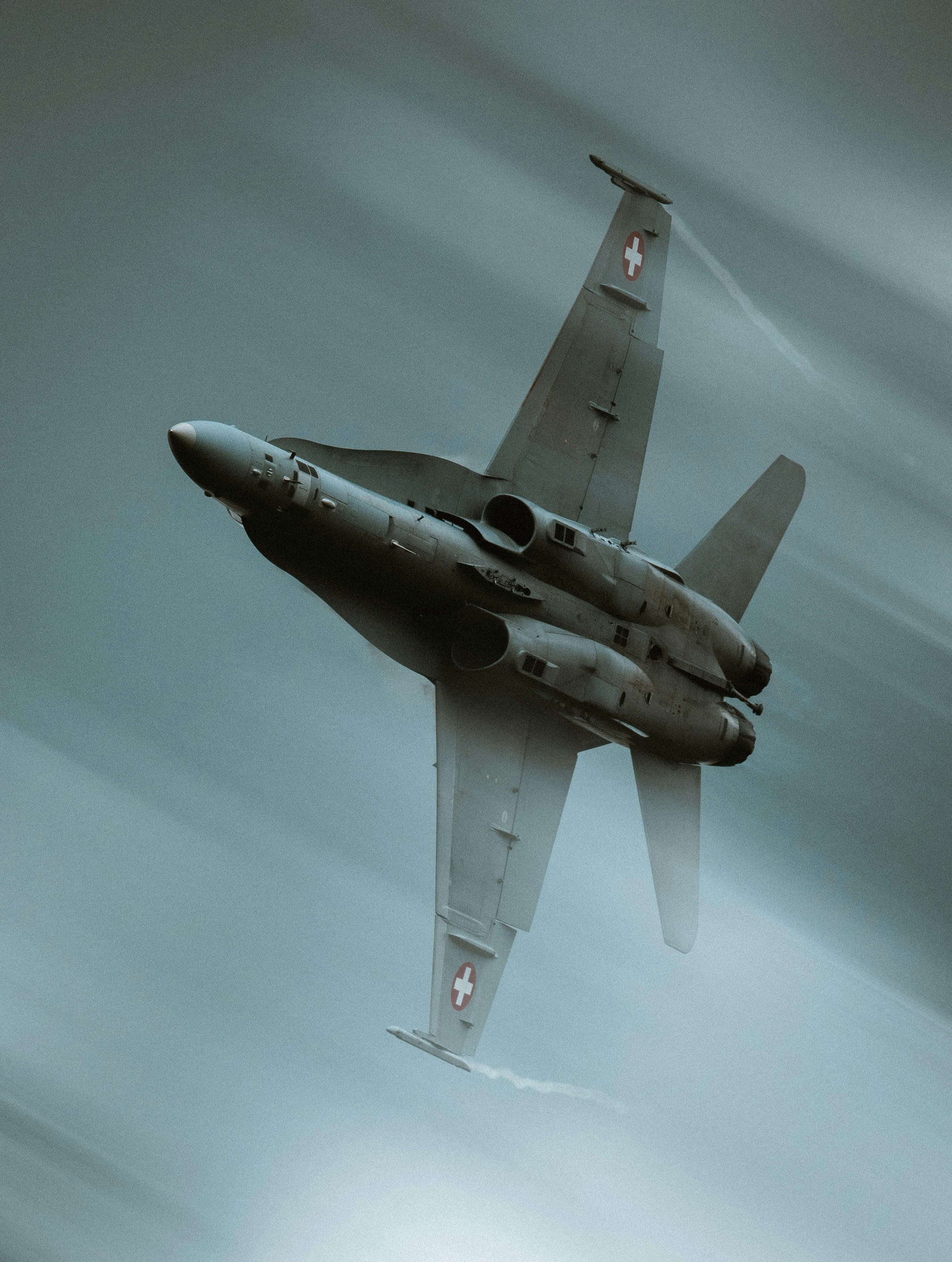 Ein Kampfjet führt ein scharfes Manöver am Himmel aus.