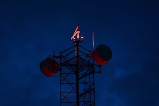 Cell tower with red lights against dark sky