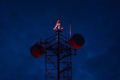 Cell tower with red lights against dark sky