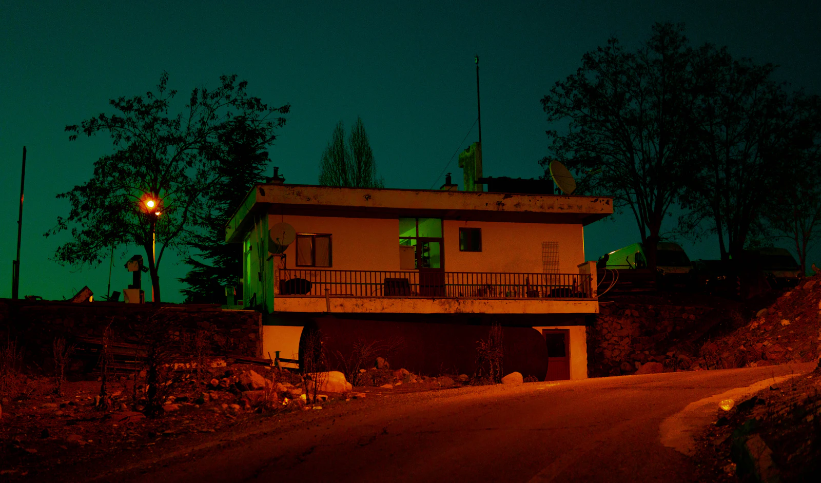 A house glowing with warm light at night while the neighborhood around it is dark