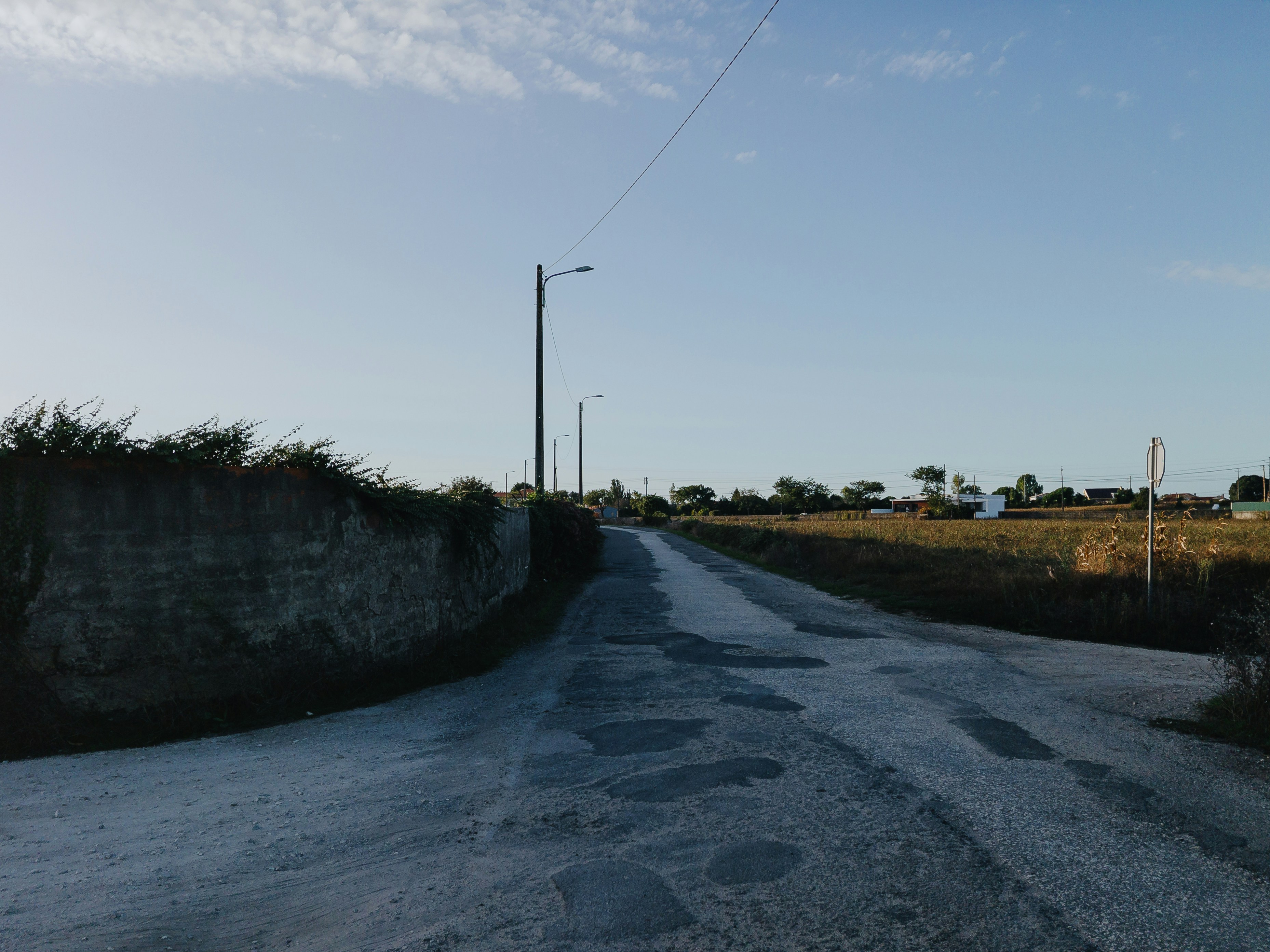 Una strada asfaltata si snoda attraverso un paesaggio rurale.