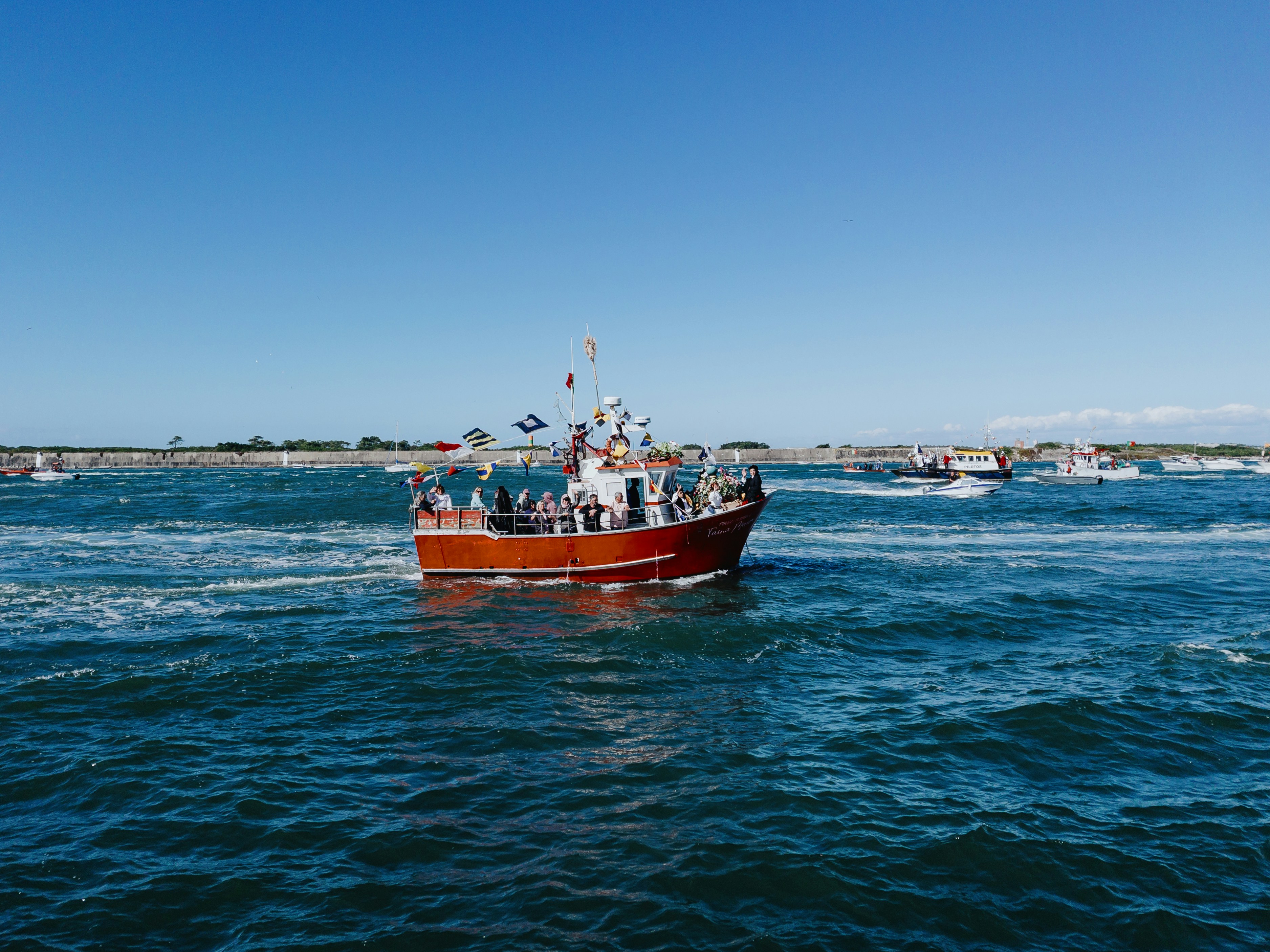 Un peschereccio rosso naviga sull'oceano blu.