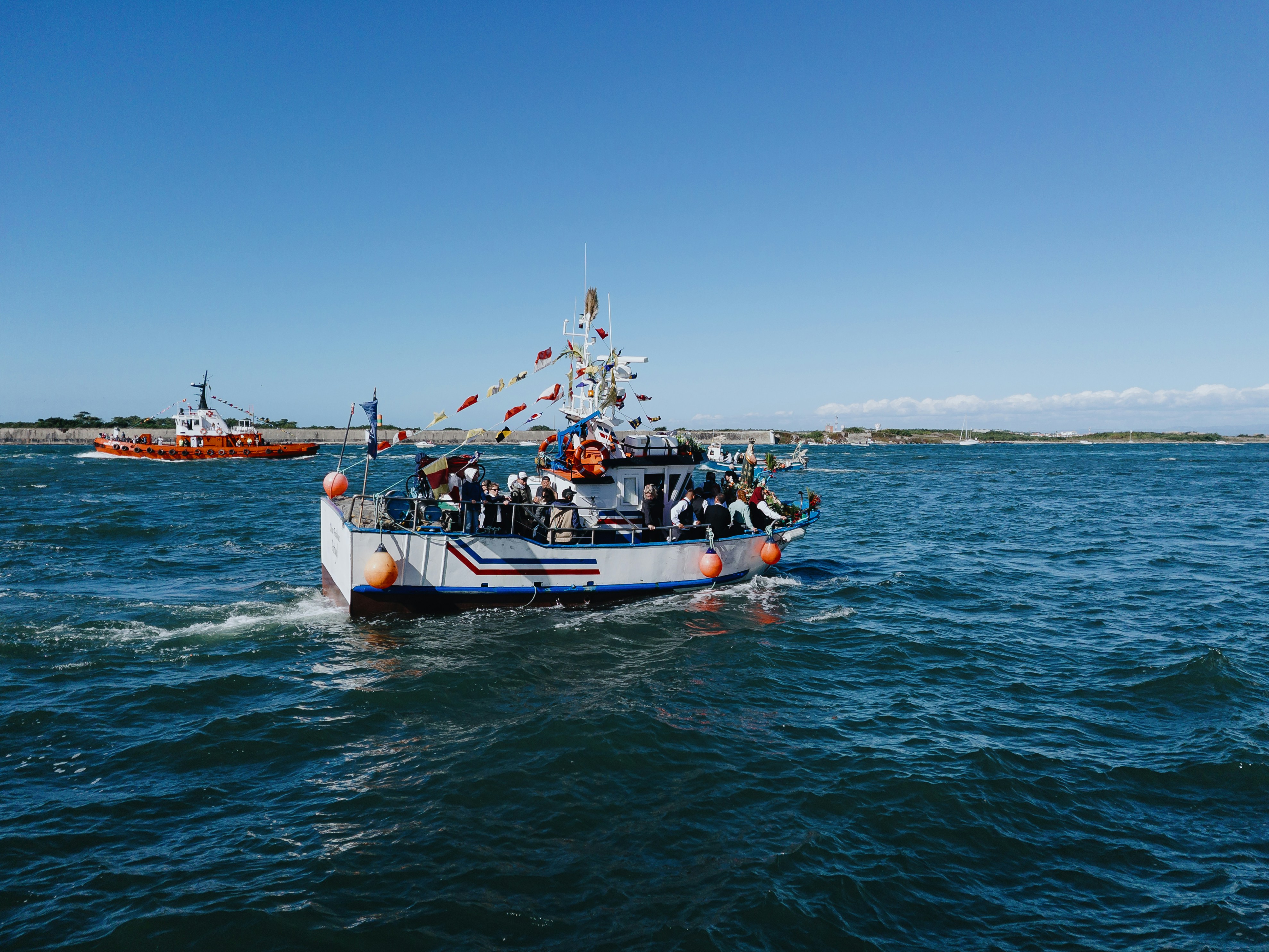 Una barca piena di persone che navigano sull'oceano.