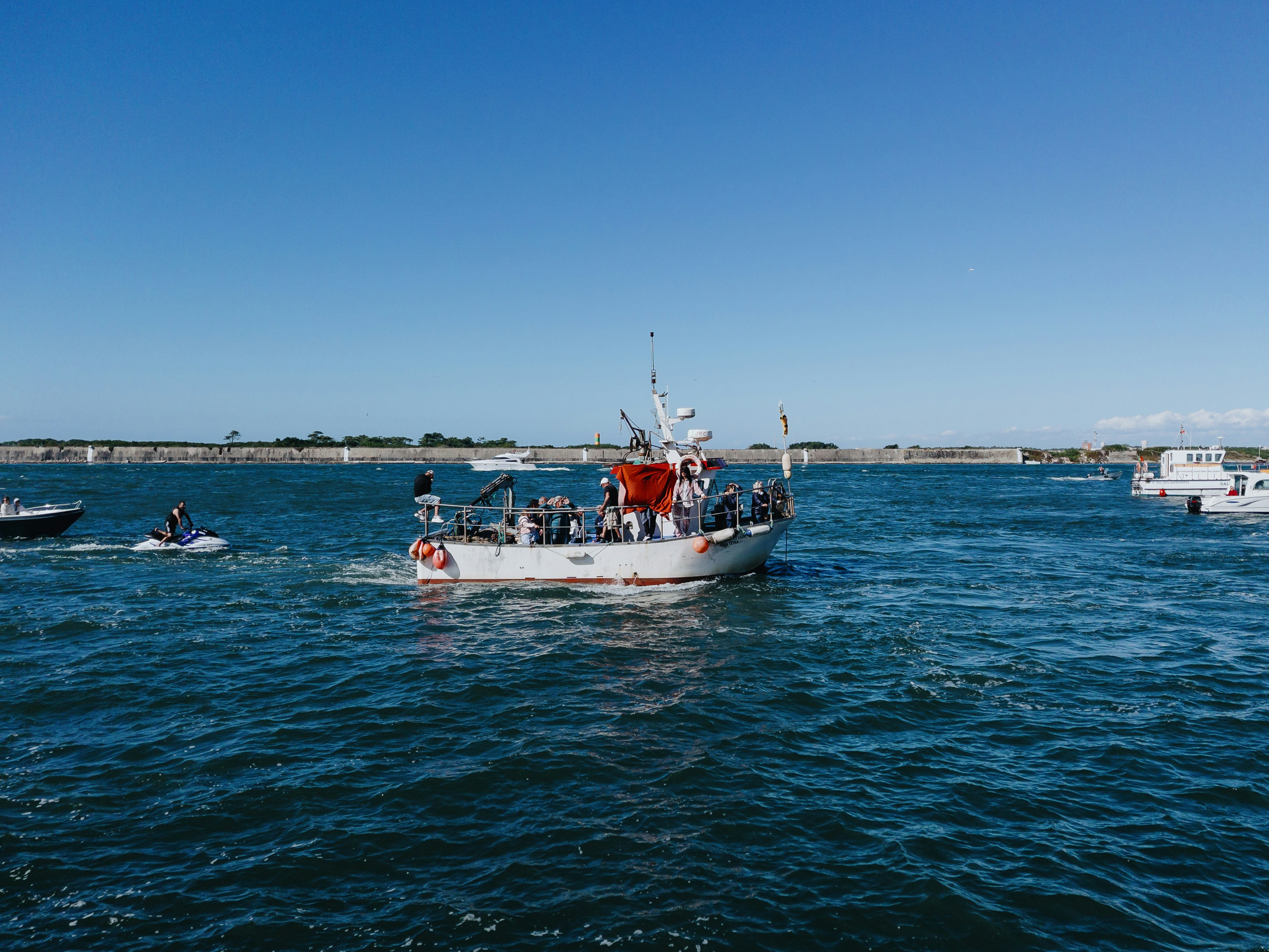 Una barca bianca con persone naviga sull'oceano blu.