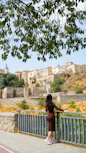 Woman on bridge overlooking historic city buildings