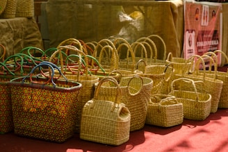 Woven straw baskets with colorful handles displayed