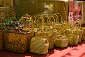 Woven straw baskets with colorful handles displayed