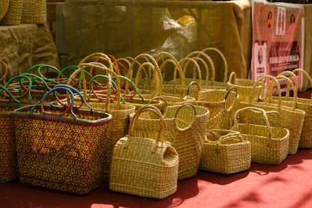 Woven straw baskets with colorful handles displayed