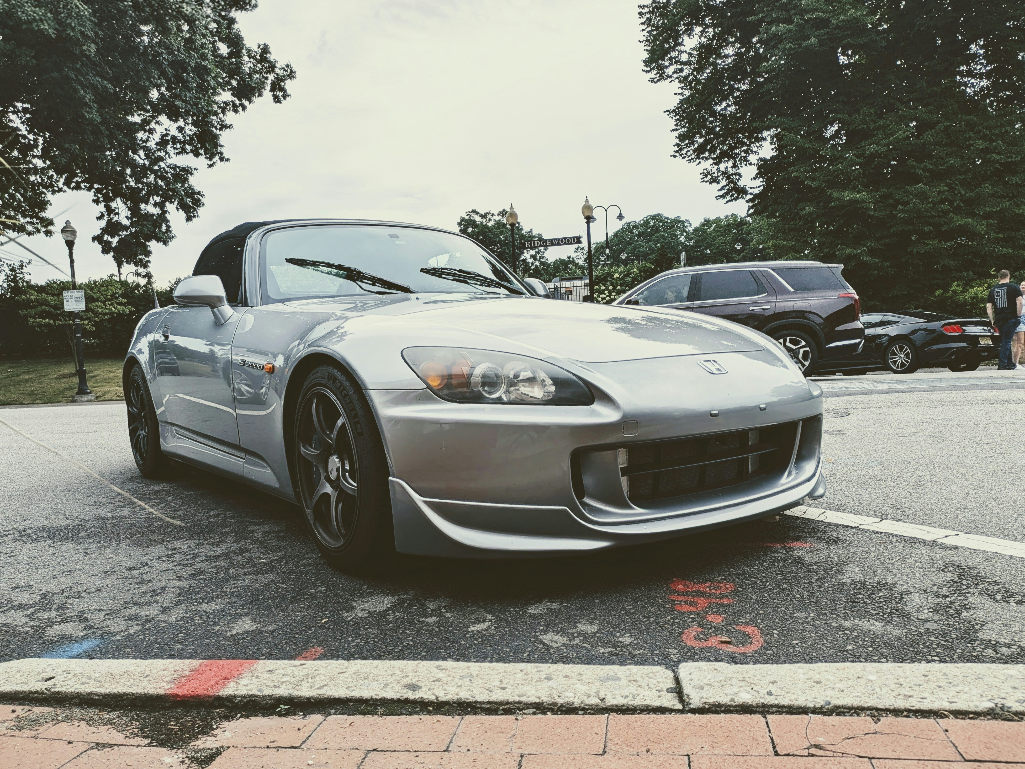 Silver convertible sports car parked on street.