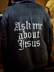 Back of hoodie with "ask me about jesus" text.