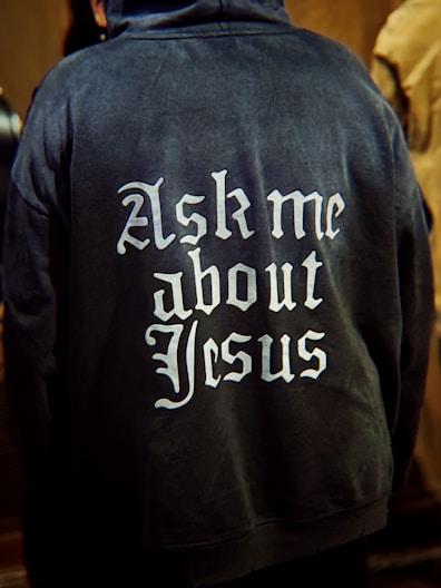 Back of hoodie with "ask me about jesus" text.