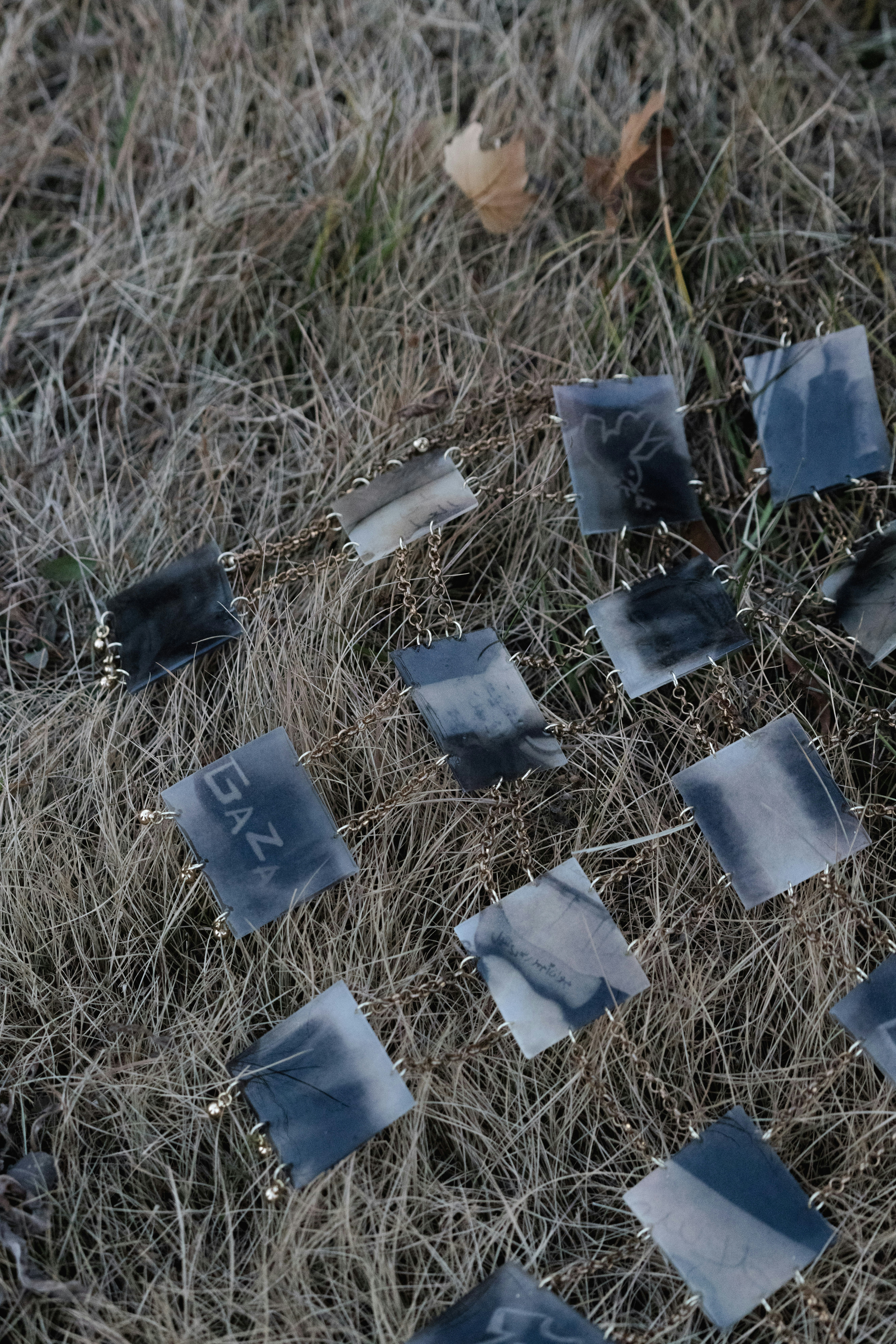 Square pendant necklace scattered on dry grass