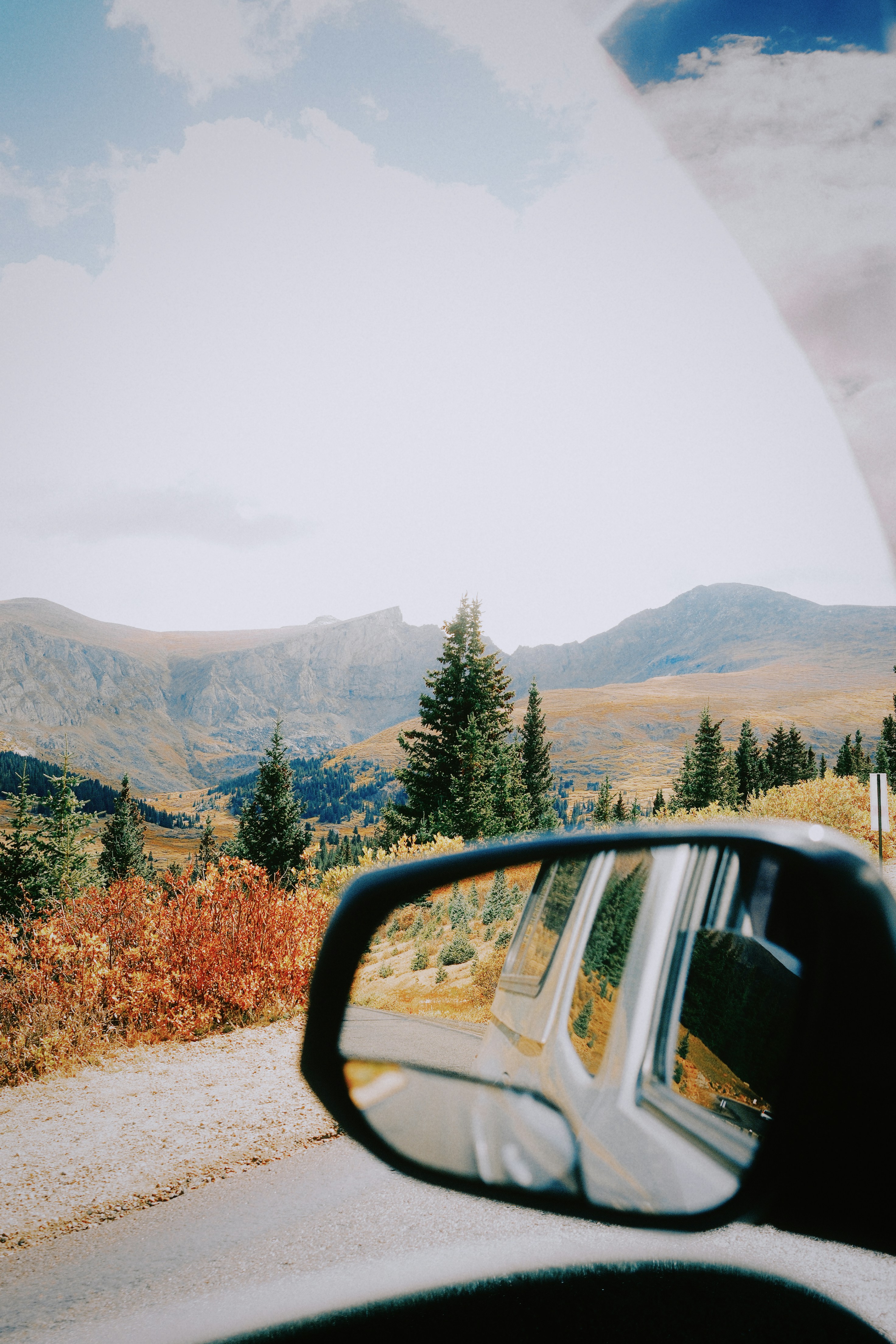 Mountain landscape reflected in car's side mirror