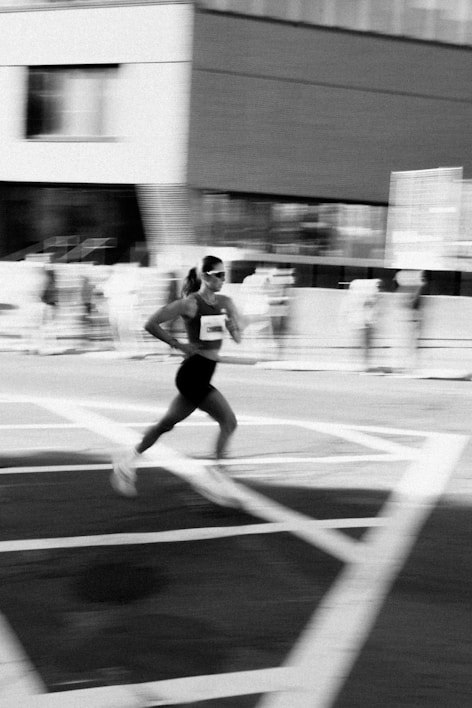 A woman running a race with blurred background.