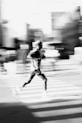 Man running across a crosswalk with motion blur