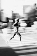Man running across a crosswalk with motion blur
