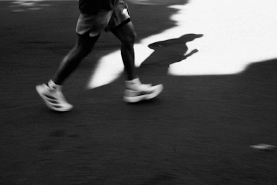 Runner's legs in motion with a long shadow.