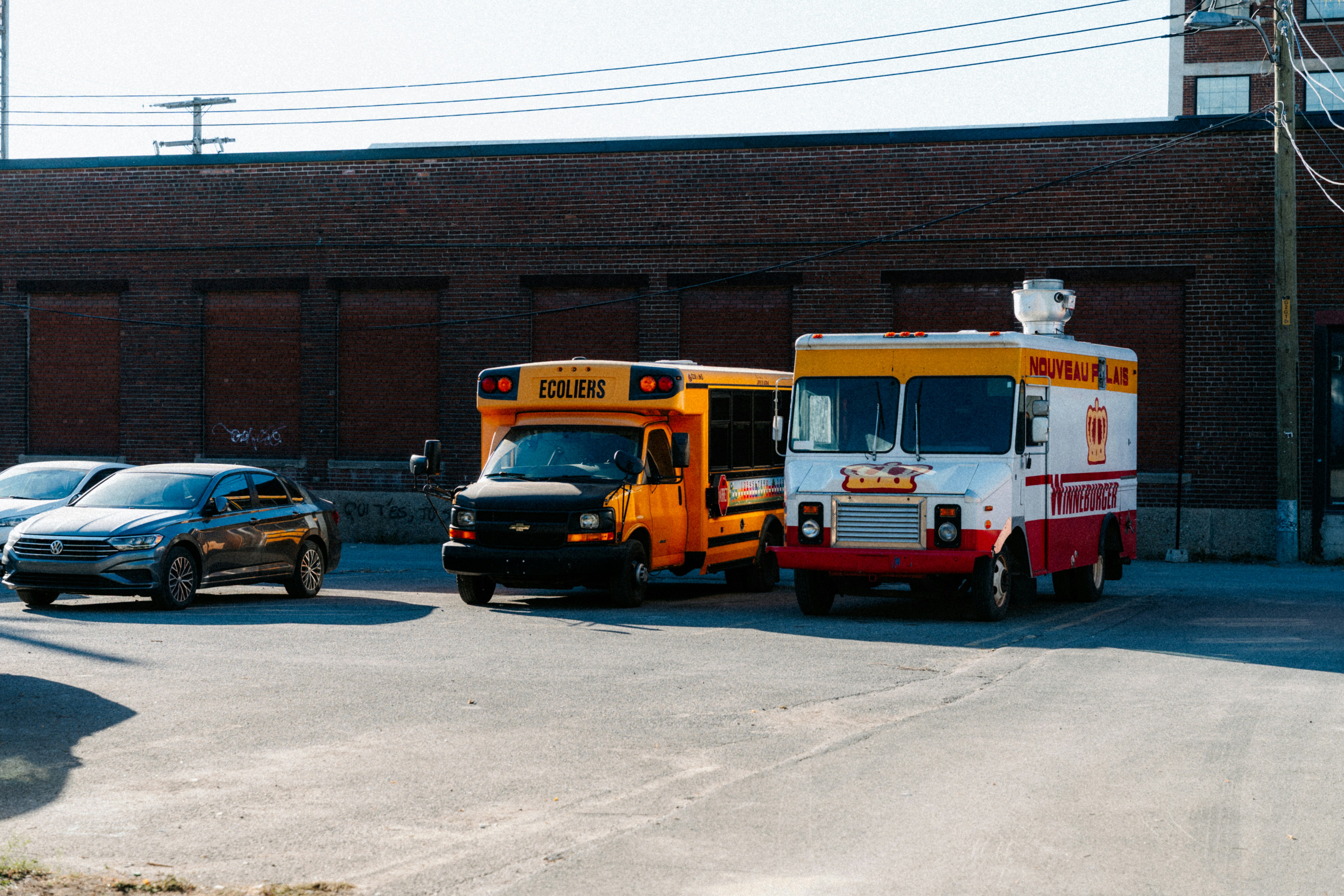 Yellow school bus and food truck parked outside building