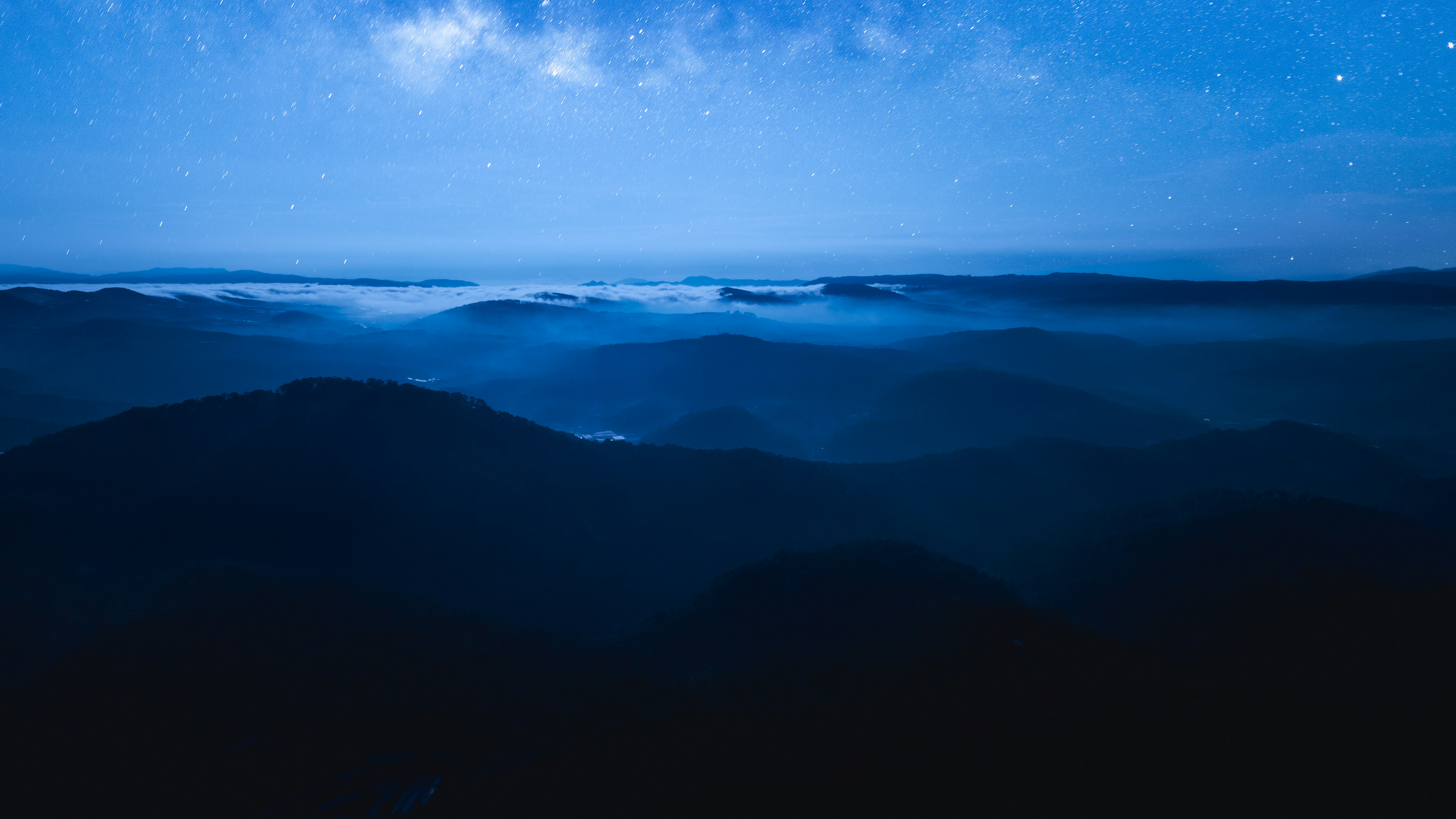 Nebelige Berge unter einem sternenklaren Nachthimmel