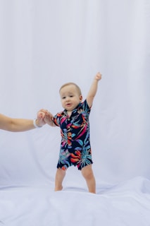 Baby in hawaiian shirt with arm raised