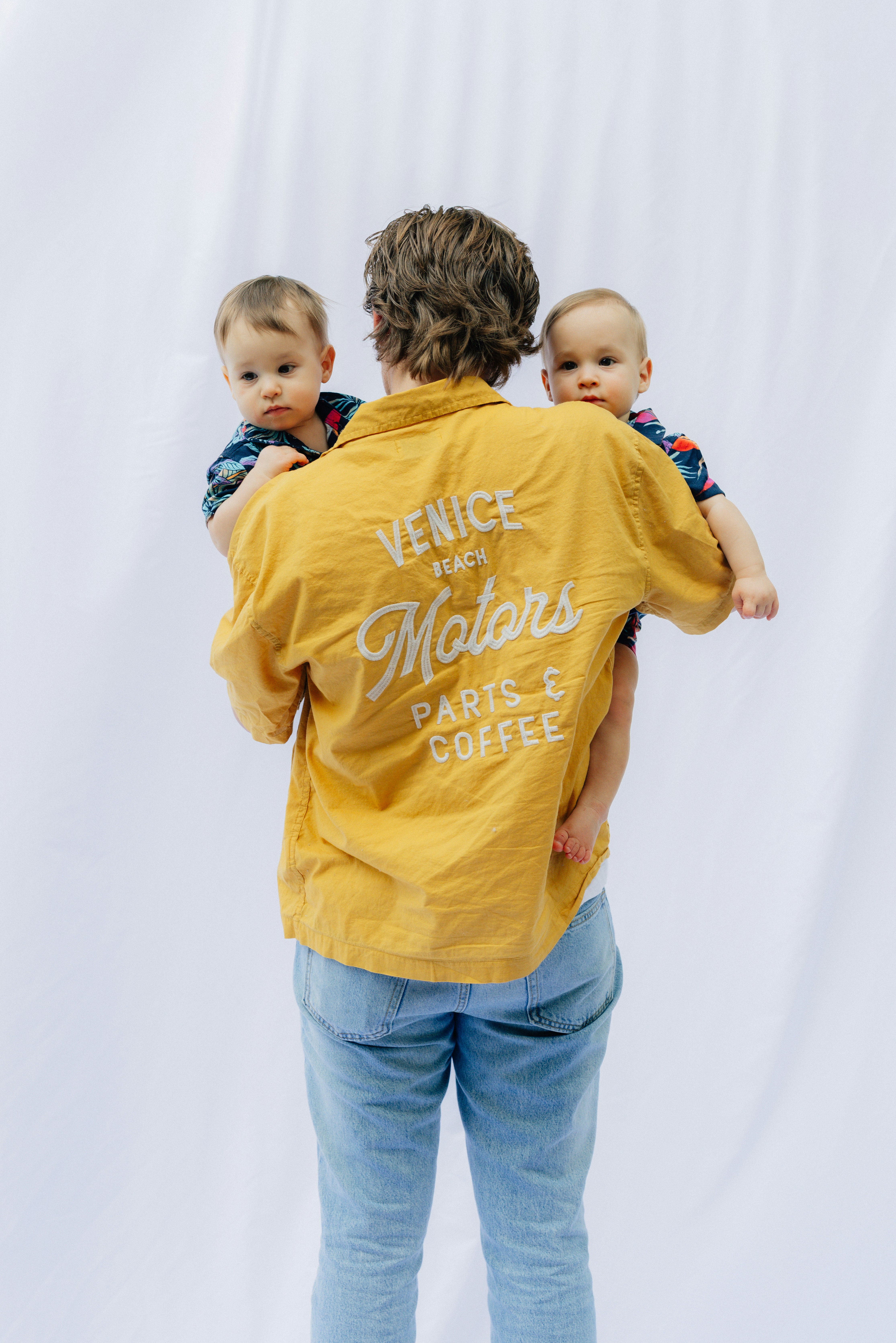 Person holding two babies against white background